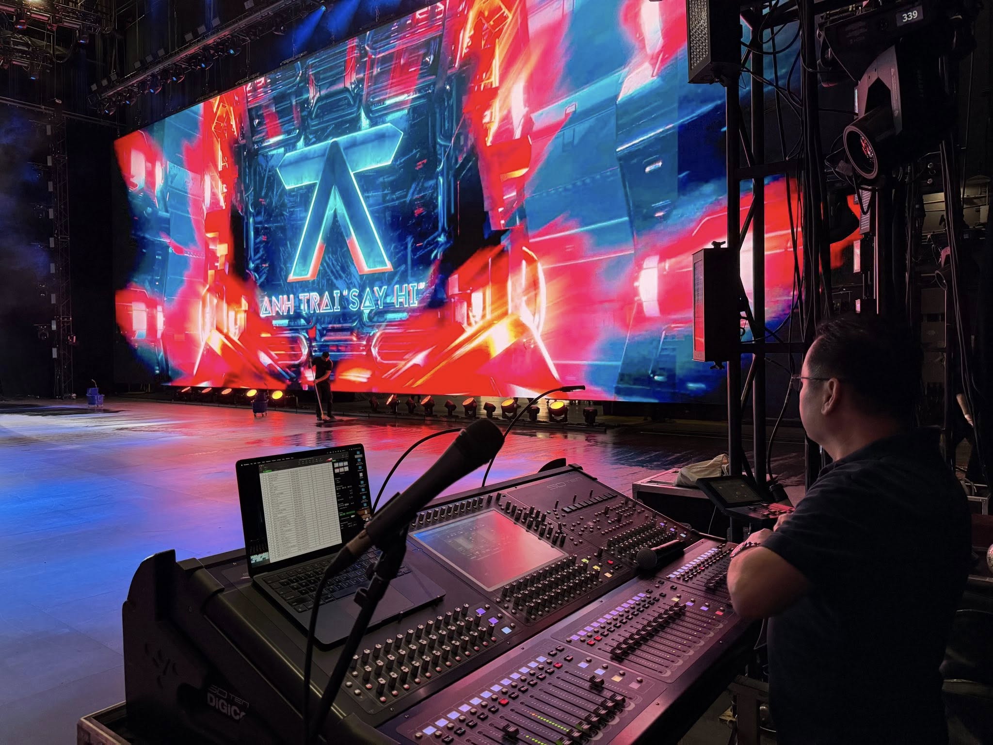 FOH audio engineer at console mixing live concert